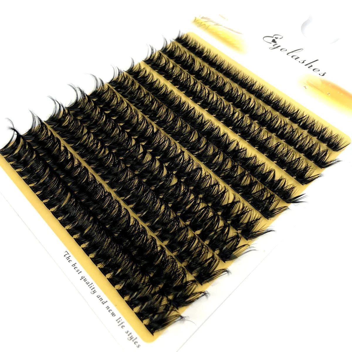 A fan-shaped cluster of black mink eyelashes displayed on a yellow background.
