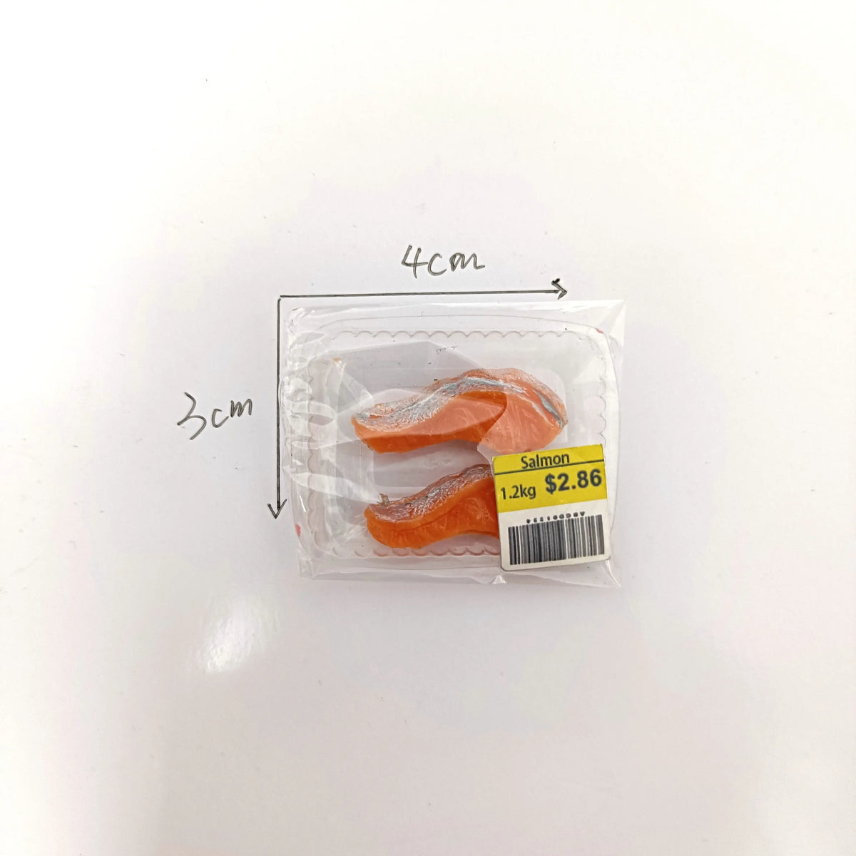 Petit emballage plastique contenant un produit saumon, dimensions indiquées à 3cm par 4cm.