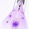 A close-up view of an ultrasonic electric dental cleaner emitting a purple light beam that disinfects viruses and bacteria.
