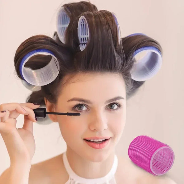 A woman is using self-grip hair curlers for heatless styling on her hair.