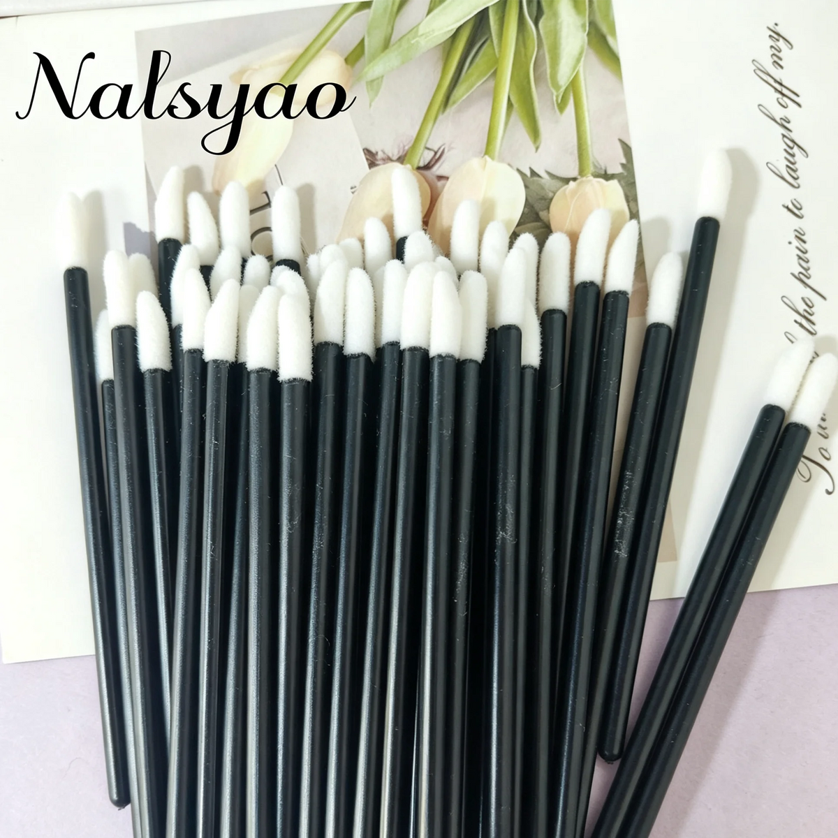 A set of 50 black and white disposable lip applicator brushes displayed on a light background.