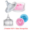 A set of two clear glass storage boxes and one pink velvet powder puff.