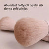 A close-up of a fluffy, light pink crystal silk makeup brush with dense soft bristles.