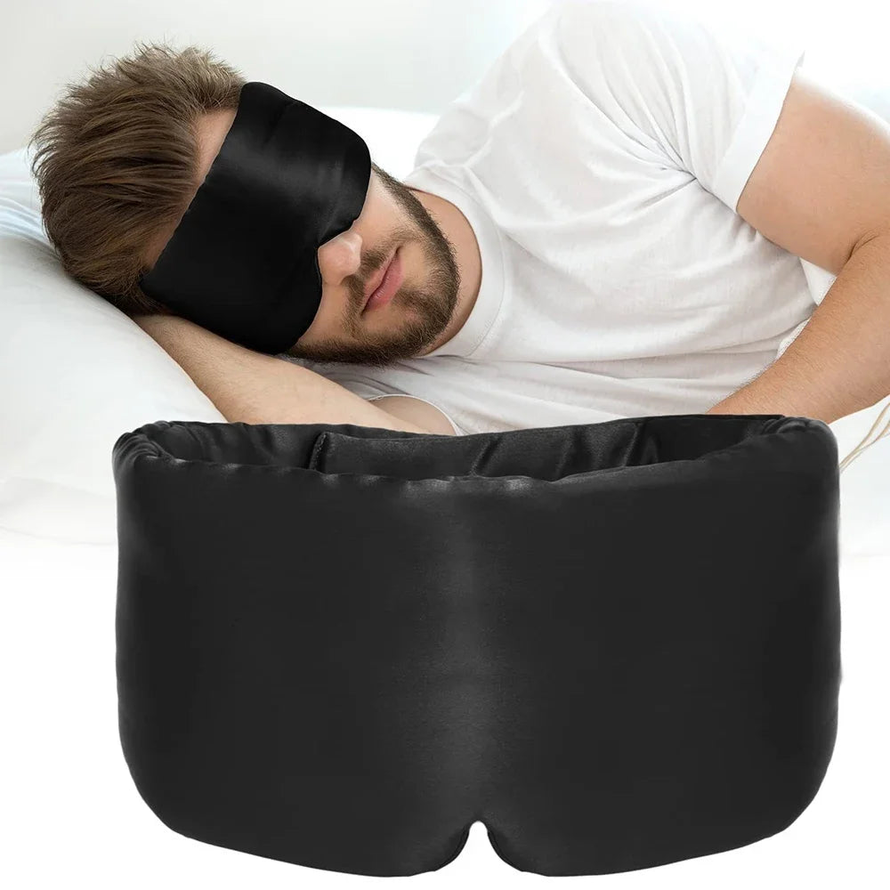 Eine schwarze Seiden-Schlafmaske wird von einer Person getragen, die liegt.