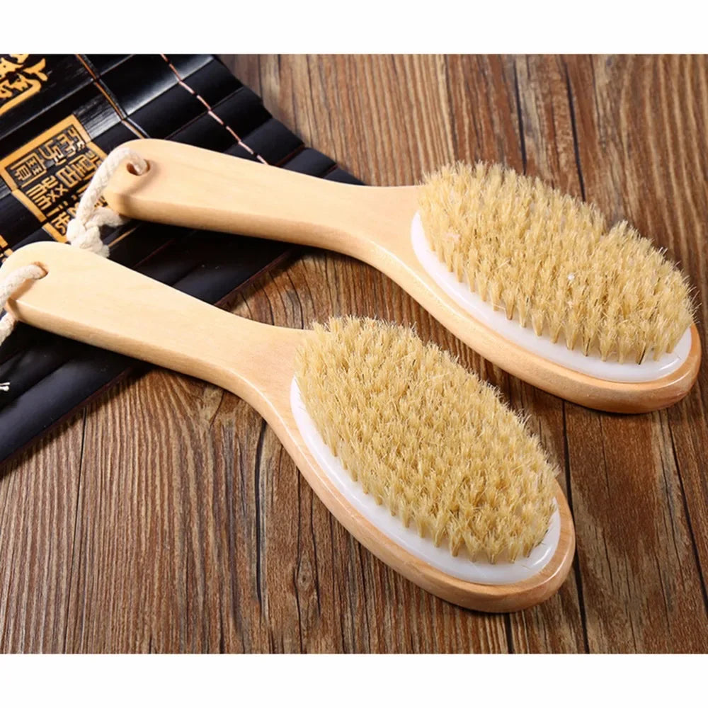 A pair of natural wooden body brushes with light yellow bristles are shown on a wooden surface.