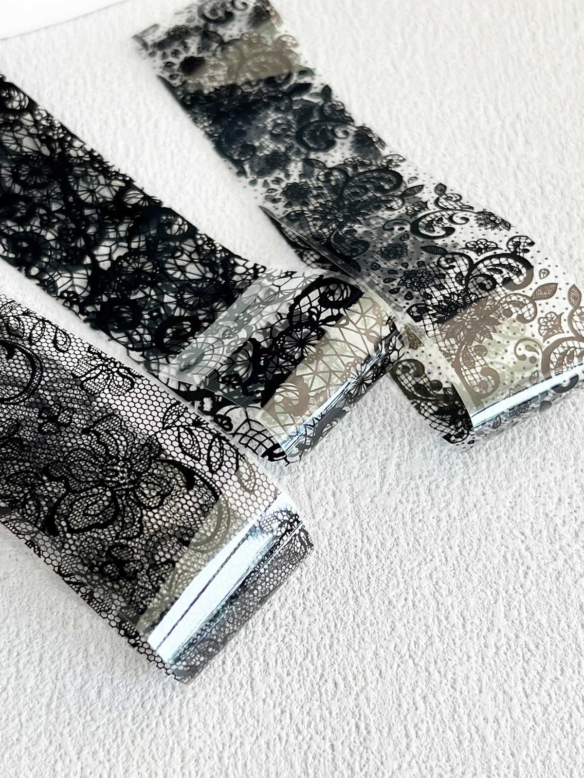 Un ensemble de décalcomanies en feuille de gants et argent noir et blanc sur une surface blanche.
