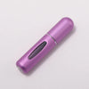 A slender, metallic purple portable refillable perfume bottle viewed from the side.