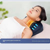 A woman is using an electric massage pillow on her neck and shoulder for relief.
