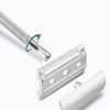 A vintage double edge safety razor kit showing the handle and blade assembly.