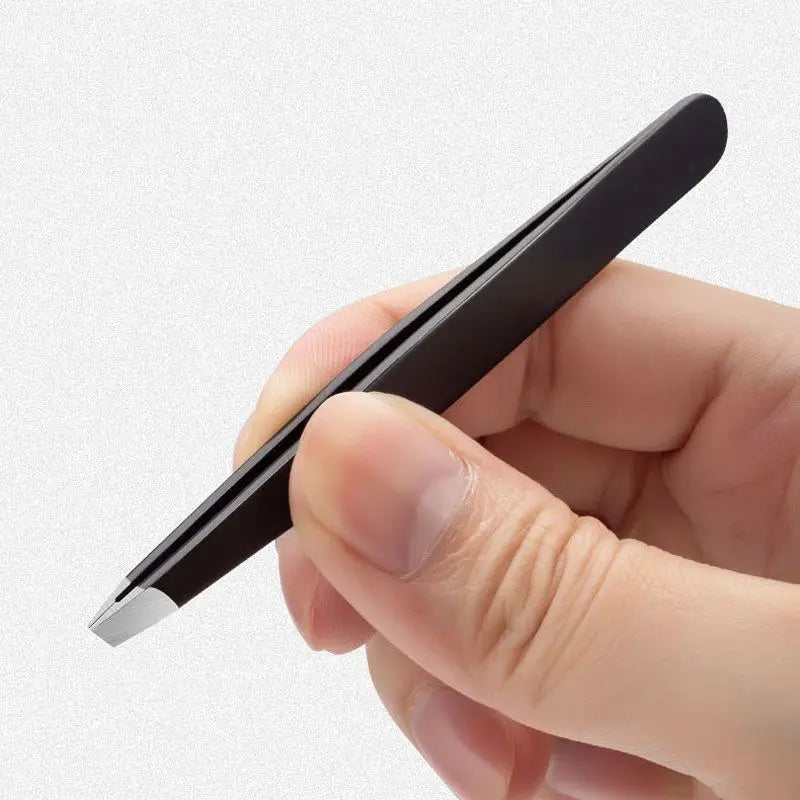 A hand holds a black precision stainless steel eyebrow tweezers with a silver tip.