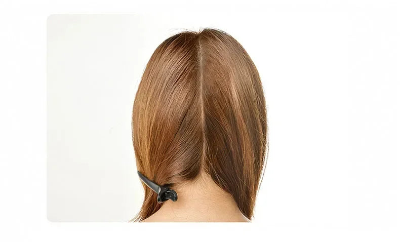 A close-up view of a person's hair with a professional dry hair trimmer being used on the back of the head.