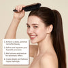 A woman is using a boar bristle hair brush to style her dark hair into a ponytail.