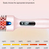 A pink heated hair brush displaying a temperature of 410F, with a scale showing various temperatures.
