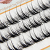 Close-up of natural wispy eyelash extensions in clusters displayed on a white background.