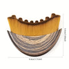 A wooden lymphatic contour face brush with golden bristles and a curved wooden base.