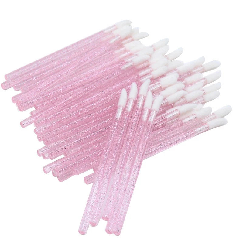 A collection of pink and white crystal lip brushes and lash spoolies arranged in a fan shape.