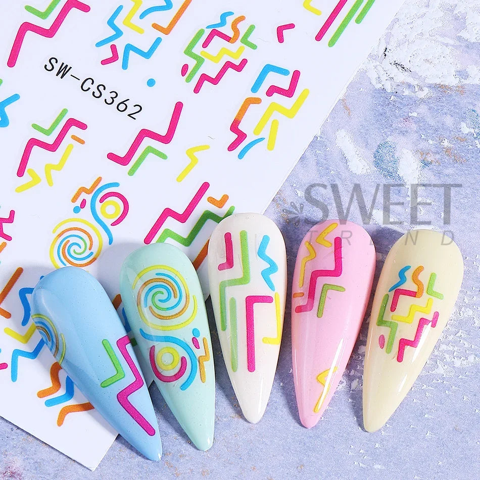 Colección de uñas acrílicas coloridas con diseños abstractos de espirales y zigzags sobre fondo blanco.