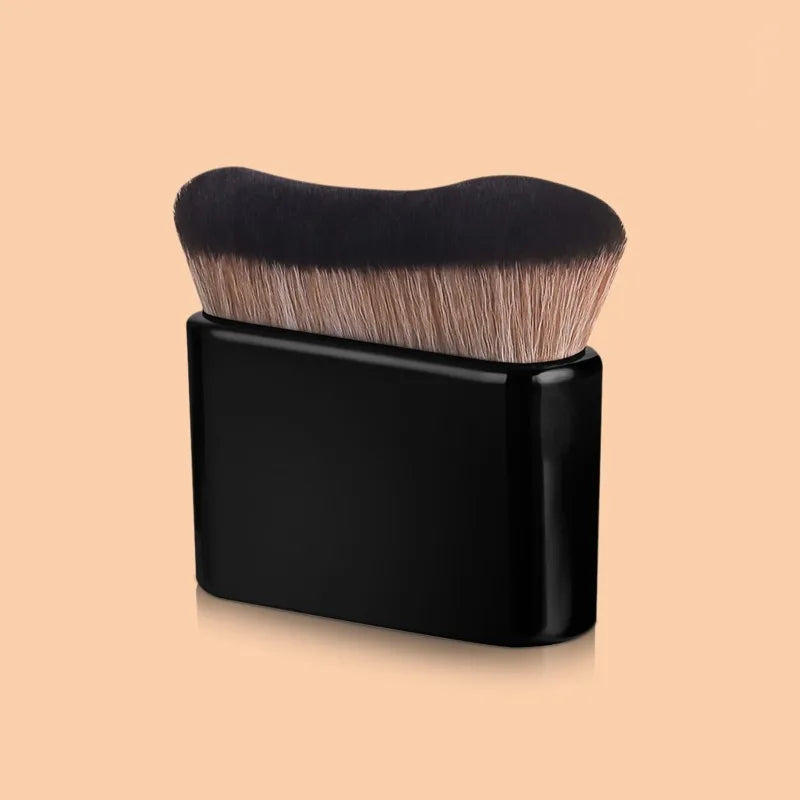 A black precision hand-held foundation makeup brush with light blonde bristles resting in a black holder.