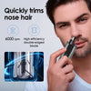 A man is using a portable electric nose hair trimmer to trim facial hair.