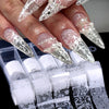 Gros plan sur des doigts montrant de longues ongles en acrylique décorés de décals de dentelle foil blanc et noir.
