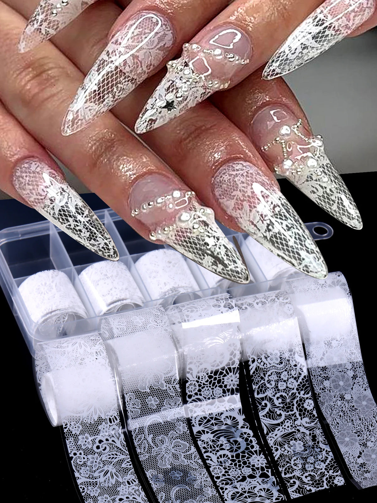 Gros plan sur des doigts montrant de longues ongles en acrylique décorés de décals de dentelle foil blanc et noir.