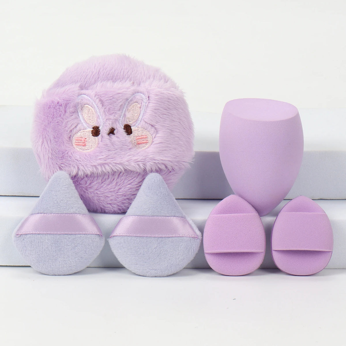Un set de poudres légères brodées violet et lavande avec un visage de lapin.