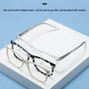A pair of clear eyeglasses with black and white patterned frames is displayed on a white box.