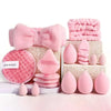 A pink complete makeup tool set featuring fluffy brushes, puffs, and accessories arranged on a white surface.