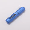 A sleek, light blue portable refillable perfume bottle with a silver cap, shown diagonally on a white background.