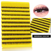 A yellow plastic lash tray showing multiple rows of individual black false eyelashes for eye extensions.