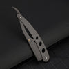 A black manual straight edge shaver kit with a curved blade is shown on a dark surface.