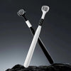 Un set de trois brosses à dents inclinées avec des manches noir et blanc posées sur une surface sombre et texturée.