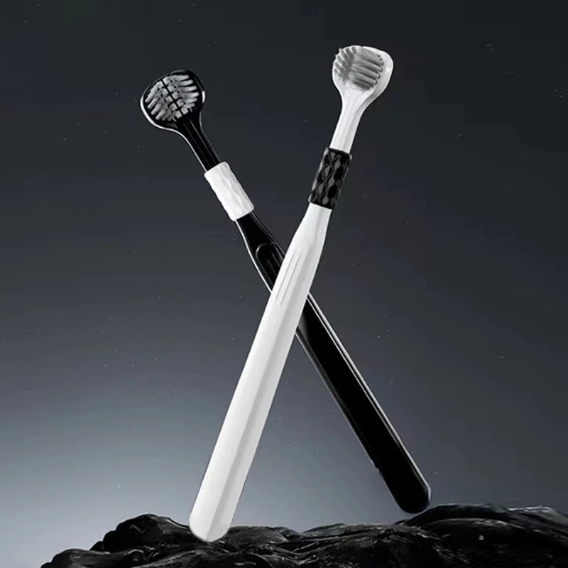 Un set de trois brosses à dents inclinées avec des manches noir et blanc posées sur une surface sombre et texturée.