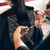 A person uses a reusable silicone hair dyeing cape and cutting collar to style hair.