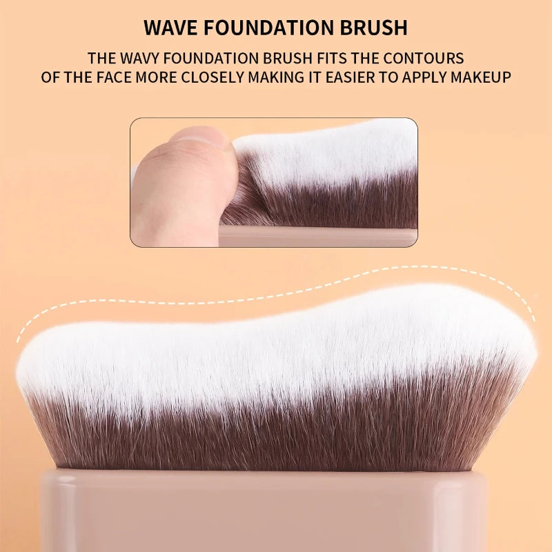 A close-up view of a wave foundation brush with brown and white bristles resting on a light-colored surface.