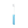 Une mini brosse à dents pliable bleu clair avec une tête de brosse blanche.