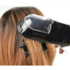 A hand is using a black professional dry hair trimmer on a person's hair.