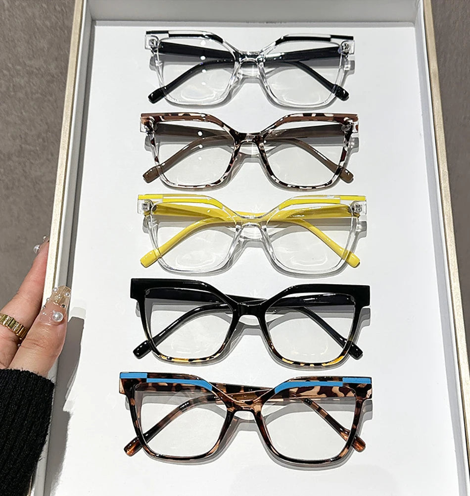 Exhibición de siete pares de gafas de lectura cuadradas anti-luz azul en varios marcos y colores.