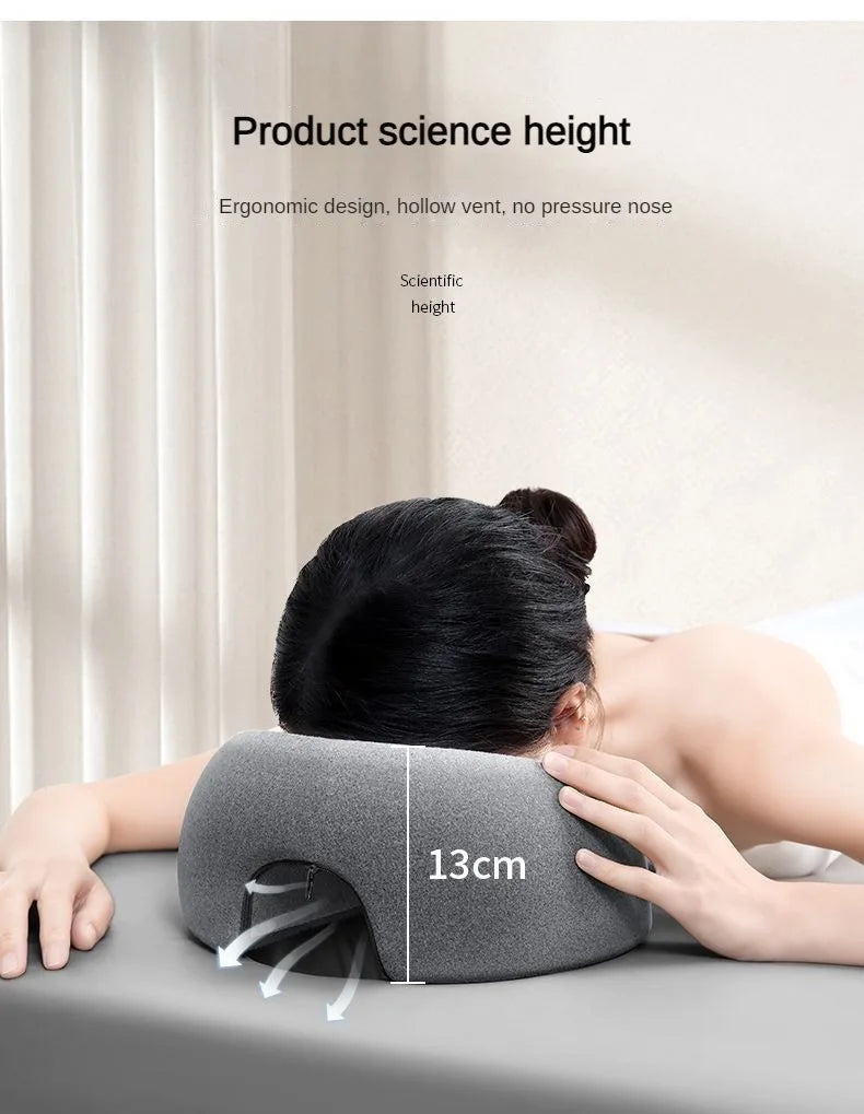 A hand is applying a gray ergonomic memory foam pillow with a 13cm height measurement to the back of a person's head.