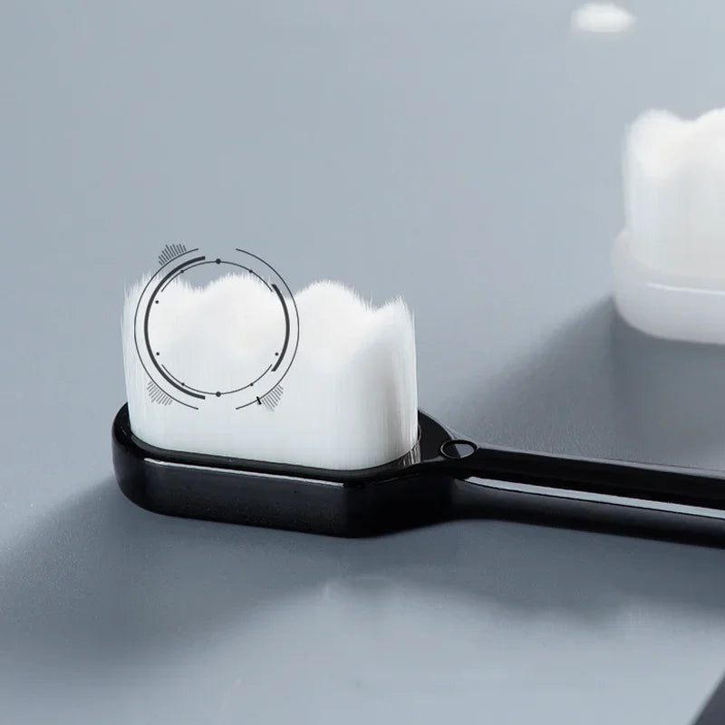 A black toothbrush with white bristles and a circular cleaning guide is shown on a gray surface.