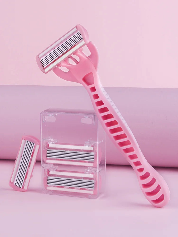 A pink 12-blade safety razor and replacement blades are displayed on a light pink surface.